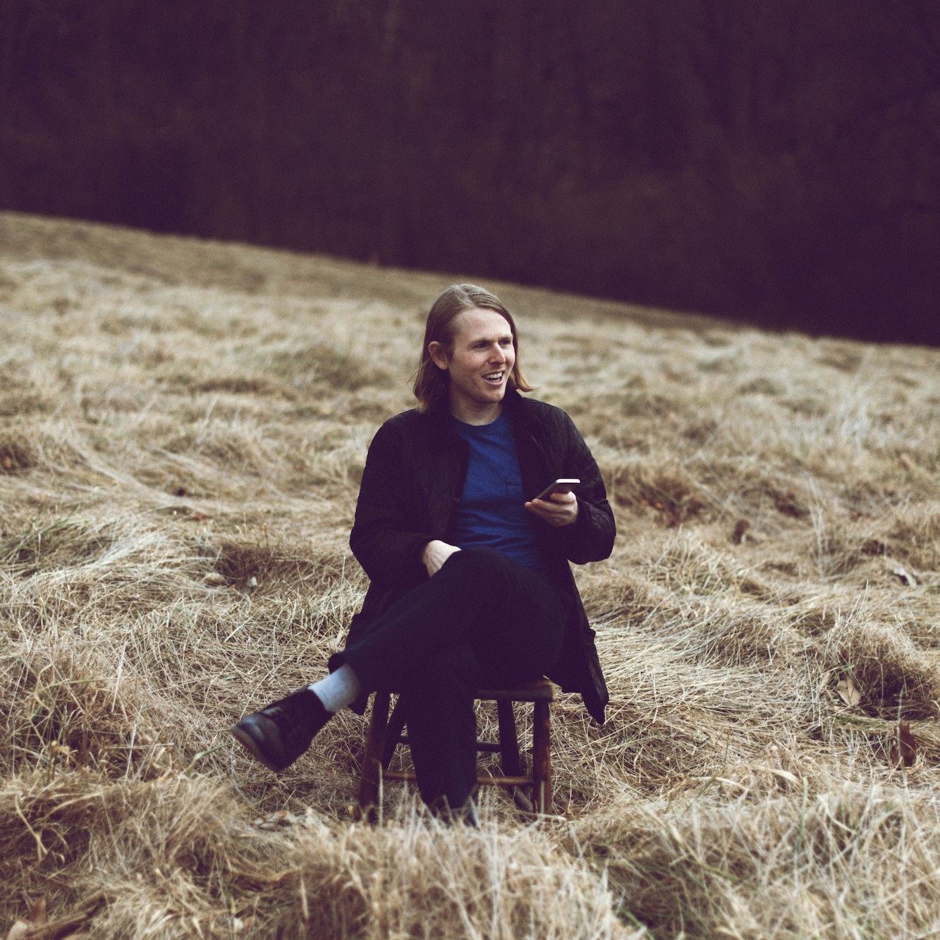 Candid photo of Andy Jenkins sitting on a chair in a field